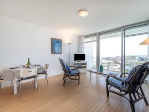 a living room with a table and chairs and a television at Apartment Les Trois Iles-10 by Interhome in Quiberon