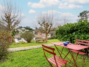 a red table and chairs in a yard at Holiday Home GACHOUNENEA by Interhome in Bidart