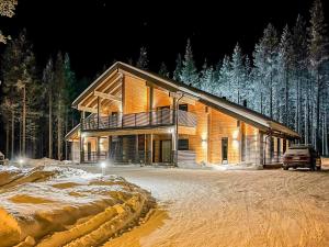 a log cabin in the snow at night at Holiday Home Tievachalets 6 b by Interhome in Sirkka