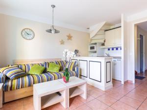 ein Wohnzimmer mit einem Sofa und einer Küche in der Unterkunft Holiday Home Domaine Golf Resort-3 by Interhome in Lacanau-Océan