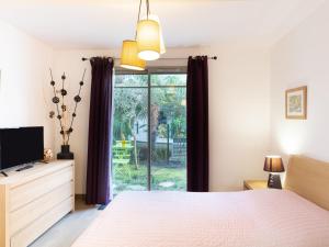 a bedroom with a bed and a tv and a window at Apartment Villa Marine by Interhome in Arcachon