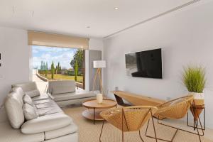 een woonkamer met een witte bank en een tv bij Villa SON SET in Costitx