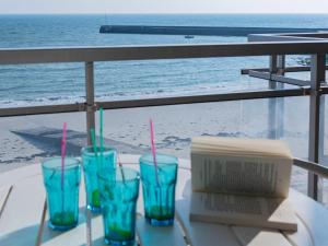 - une table avec quatre verres et une boîte sur la plage dans l'établissement Apartment Morgane by Interhome, à Saint-Pierre-Quiberon