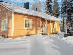 a log cabin in the snow with snow around it at Holiday Home Villa niemi by Interhome in Kotalahti