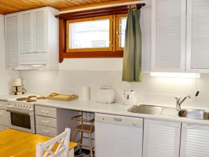 una cocina con armarios blancos y fregadero en Holiday Home Alppikylä 8b paritalo by Interhome, en Hyrynsalmi