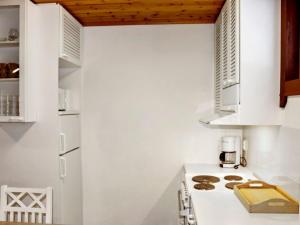 cocina blanca con estufa blanca horno superior en Holiday Home Alppikylä 8b paritalo by Interhome, en Hyrynsalmi
