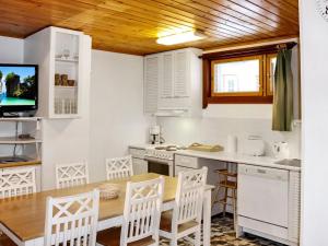 a kitchen with a table and chairs and a tv at Holiday Home Alppikylä 8b paritalo by Interhome in Hyrynsalmi