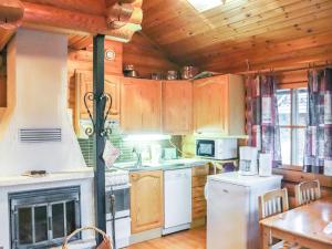 eine Küche mit Holzschränken und einem weißen Kühlschrank in der Unterkunft Holiday Home Alppi 6a paritalo by Interhome in Hyrynsalmi