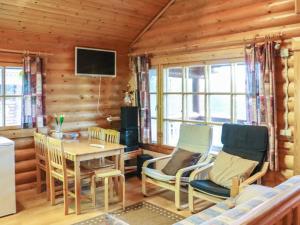 ein Wohnzimmer mit Tisch und Stühlen und einem Fernseher in der Unterkunft Holiday Home Alppi 6a paritalo by Interhome in Hyrynsalmi