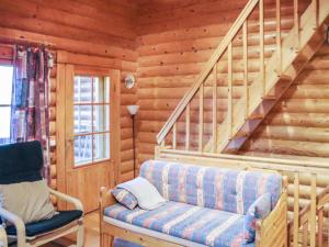 ein Wohnzimmer mit Couch und Treppe in einer Blockhütte in der Unterkunft Holiday Home Alppi 6a paritalo by Interhome in Hyrynsalmi