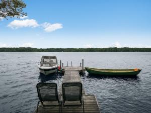 un molo con due sedie e una barca su un lago di Holiday Home Villa sieponpesä by Interhome a Paaso