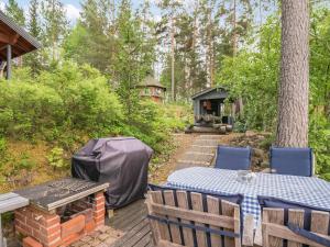 un tavolo e sedie su un ponte di legno con una griglia di Holiday Home Villa sieponpesä by Interhome a Paaso Altre 30 foto