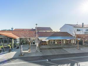 eine Gruppe von Gebäuden mit Dächern an einer Straße in der Unterkunft Holiday Home Rés de la paix by Interhome in Mimizan