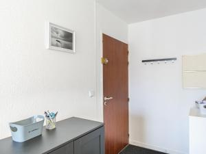 ein weißer Raum mit einem Schreibtisch und einer Tür in der Unterkunft Holiday Home Rés de la paix by Interhome in Mimizan