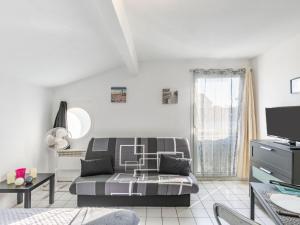 ein Wohnzimmer mit Sofa und Fernseher in der Unterkunft Holiday Home Rés de la paix by Interhome in Mimizan