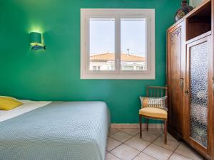 ein Schlafzimmer mit einem Bett, einem Fenster und einem Stuhl in der Unterkunft Holiday Home Milady by Interhome in Biarritz + 18 Fotos