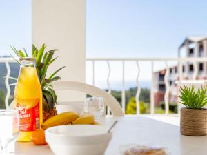 uma mesa com uma garrafa de sumo de laranja e fruta em Apartment Village Cap Estérel - Le Hameau-20 by Interhome em Agay - Saint-Raphaël