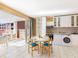 uma cozinha e sala de jantar com mesa e cadeiras em Apartment Village Cap Estérel - Le Hameau-20 by Interhome em Agay - Saint-Raphaël