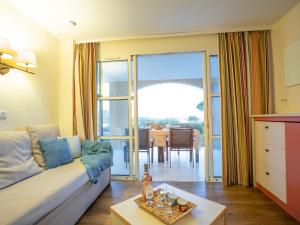 a living room with a couch and a table at Apartment Le Belvédère - V2 013 by Interhome in Agay - Saint Raphael