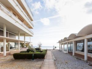 an exterior view of a building with the ocean in the background at Studio Le Grand Large-2 by Interhome in Le Lavandou