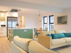 a living room with a couch and a kitchen at Holiday Home 10 Husabost by Interhome in Husabost