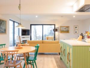 a kitchen and living room with a table and chairs at Holiday Home 10 Husabost by Interhome in Husabost +25 photos