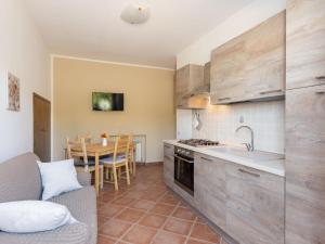 kuchnia i jadalnia z kanapą i stołem w obiekcie Apartment Benedetta by Interhome w mieście Castiglione della Pescaia