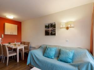 a living room with a blue couch and a table at Apartment L'Esquinade F6 225 by Interhome in Agay - Saint Raphael