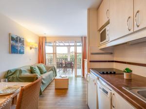 a kitchen and living room with a couch and a table at Apartment L'Esquinade F6 225 by Interhome in Agay - Saint Raphael +44 photos