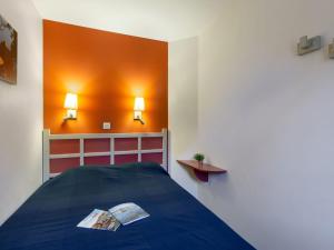 a bedroom with a bed and two lights on the wall at Apartment L'Esquinade F6 225 by Interhome in Agay - Saint Raphael
