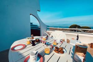 einen Tisch mit Speisen und Getränken auf dem Balkon in der Unterkunft Le Flamant in Le Grau-du-Roi
