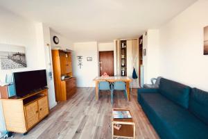 ein Wohnzimmer mit einem Sofa und einem Tisch in der Unterkunft Le Flamant in Le Grau-du-Roi