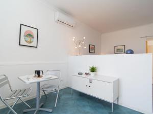 a white kitchen with a table and chairs at Apartment La Penultima-2 by Interhome in Ischia