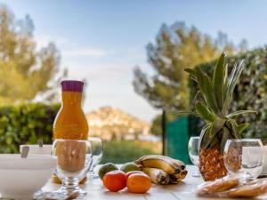 a table with a bottle of juice and fruit on it at Apartment L'Esquinade - FH 012 by Interhome in Agay - Saint Raphael