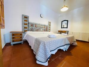 Albergue Hospedería Montaña Morciguillinas في Cortijos Nuevos: غرفة نوم بسرير وخزانة وطاولة