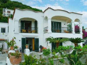 una casa blanca con plantas delante en Apartment La Penultima-4 by Interhome en Ischia