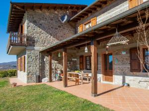 a stone house with a patio and a table at Apartment Il Girasole by Interhome in Piazza al Serchio