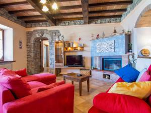a living room with two red couches and a fireplace at Apartment Il Girasole by Interhome in Piazza al Serchio