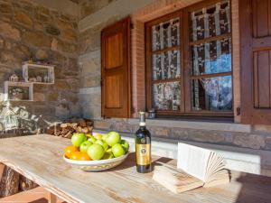 a bottle of wine sitting on a table with a bowl of fruit at Apartment Il Girasole by Interhome in Piazza al Serchio