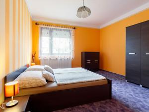 a bedroom with a bed with yellow walls and a window at Apartment May by Interhome in Balatonlelle