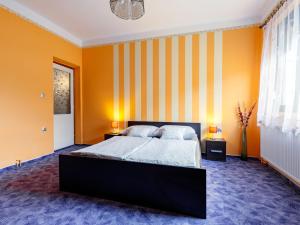 a bedroom with orange walls and a large bed at Apartment May by Interhome in Balatonlelle