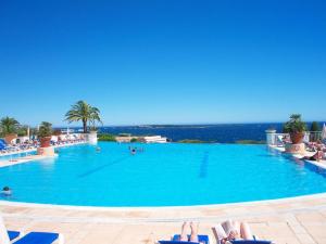 uma grande piscina com pessoas deitadas em cadeiras num resort em Apartment Villa Francia-1 by Interhome em Cannes
