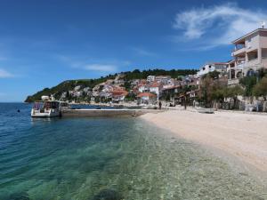 a beach with a boat in the water and houses at Holiday Home Dubra by Interhome in Komarna