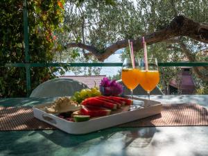 a tray of fruit and two glasses of juice on a table at Holiday Home Dubra by Interhome in Komarna