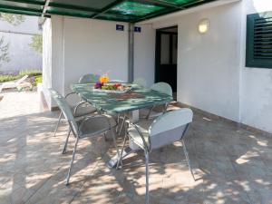 a table with chairs and a bowl of fruit on it at Holiday Home Dubra by Interhome in Komarna