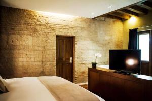 a bedroom with a bed and a flat screen tv at Hotel Boutique Casa Madero in Morelia