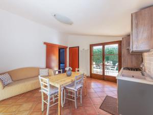 a kitchen and living room with a wooden table and chairs at Holiday Home Alma by Interhome in Castiglione della Pescaia