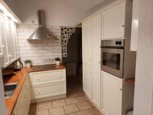een keuken met witte kasten en een fornuis met oven bij Apartament Przy Ratuszu in Boguszów-Gorce