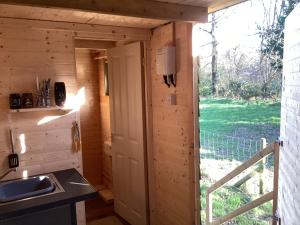 una cocina en una casa pequeña con ventana en Vigo Retreat cabin 1 en Sevenoaks