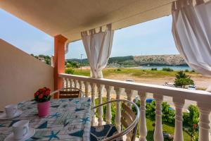 balcón con mesa y vistas al océano en Apartments Lino, en Lopar